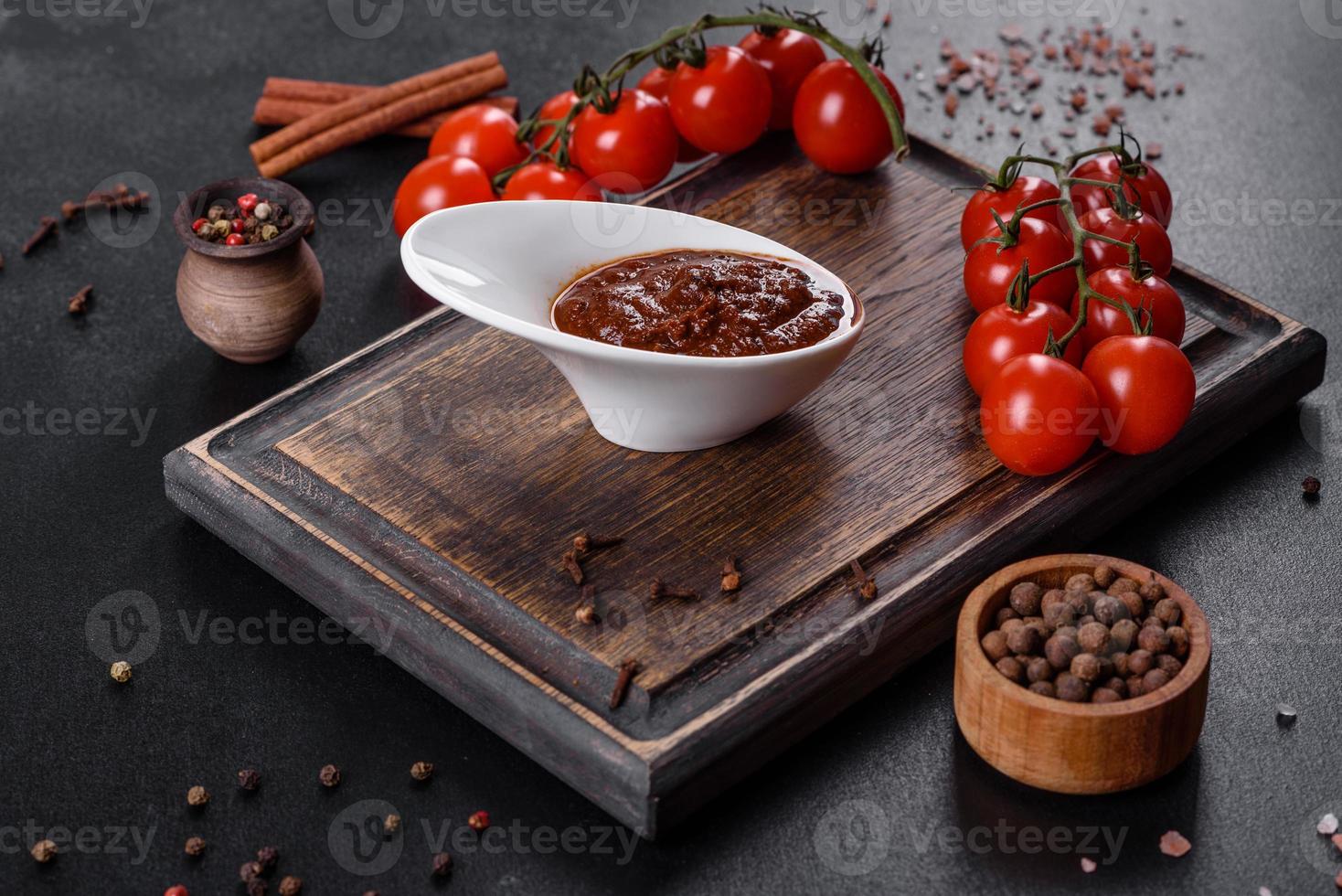 rote Soße oder Ketchup in einer Schüssel und Zutaten zum Kochen foto