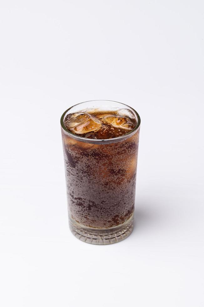 Cola im Glas mit klaren Eiswürfeln auf weißem Hintergrund foto