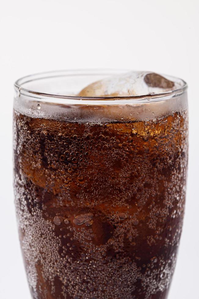 Cola im Glas mit klaren Eiswürfeln auf weißem Hintergrund foto