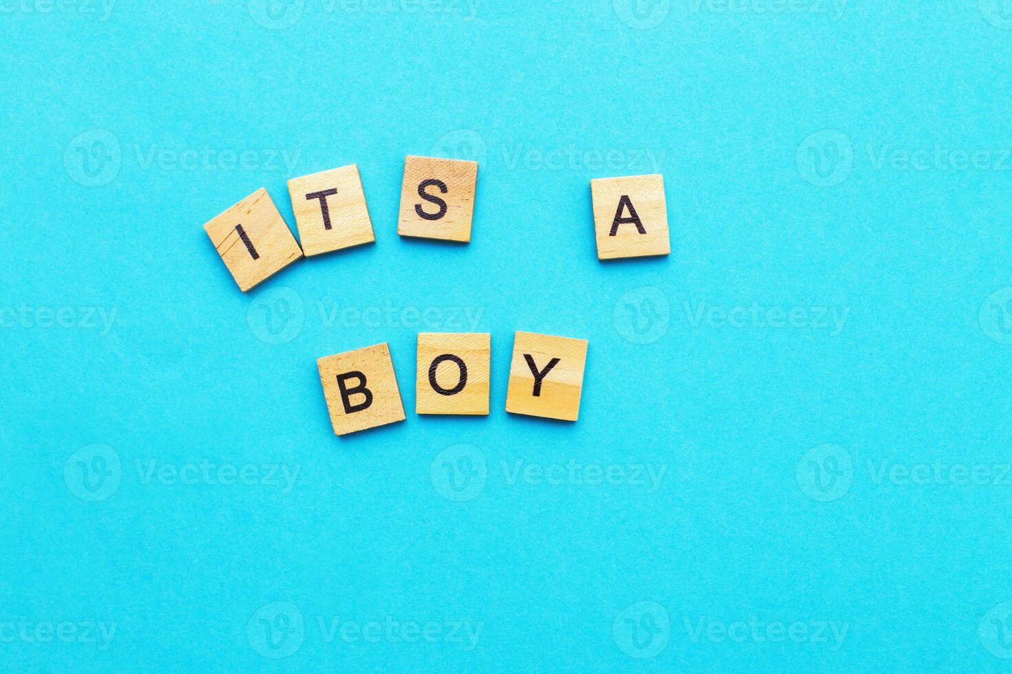 Wort es ist ein Junge durch hölzern Würfel auf ein Blau Hintergrund. Symbol von Geburt, Elternschaft, Geburt Konzept foto