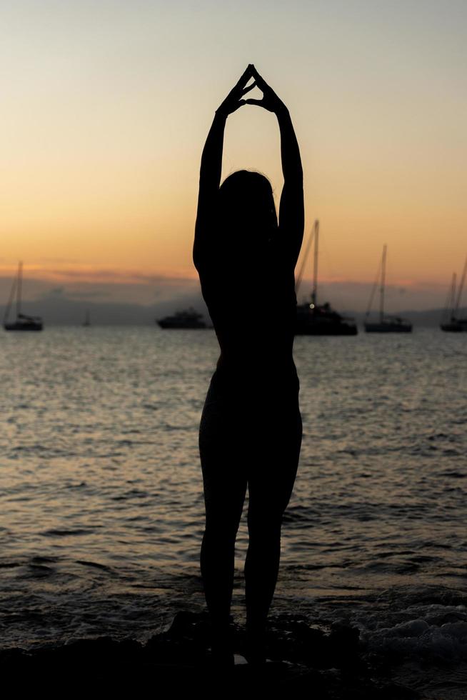 Frau, die Yoga an den Stränden von Formentera in Spanien praktiziert foto