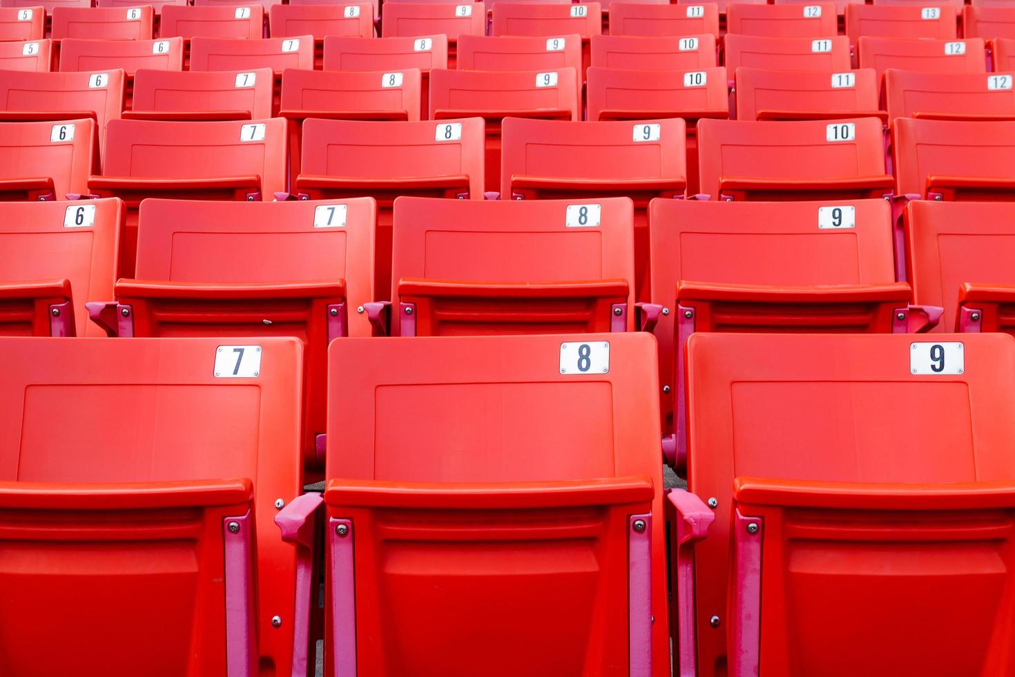 Reihe von roten Klappstühlen in einem Stadion. foto