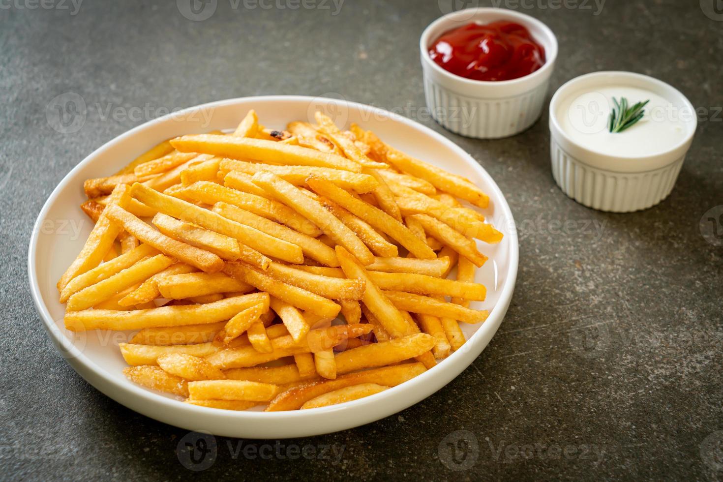 Pommes Frites mit Sauerrahm und Ketchup foto