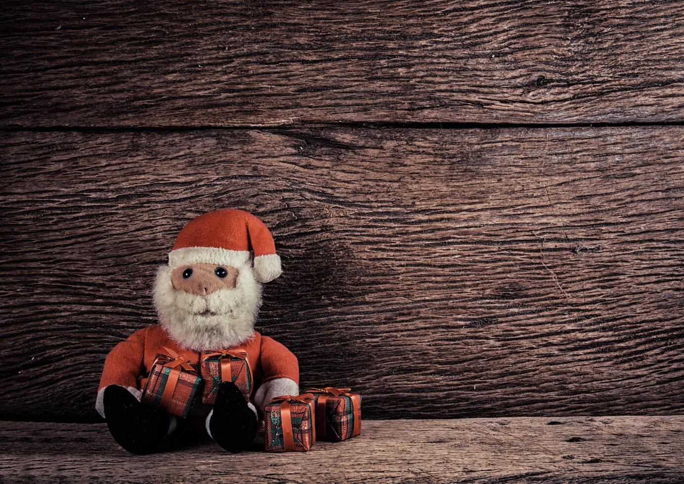 Weihnachtsmann und Geschenkbox auf Holzuntergrund foto
