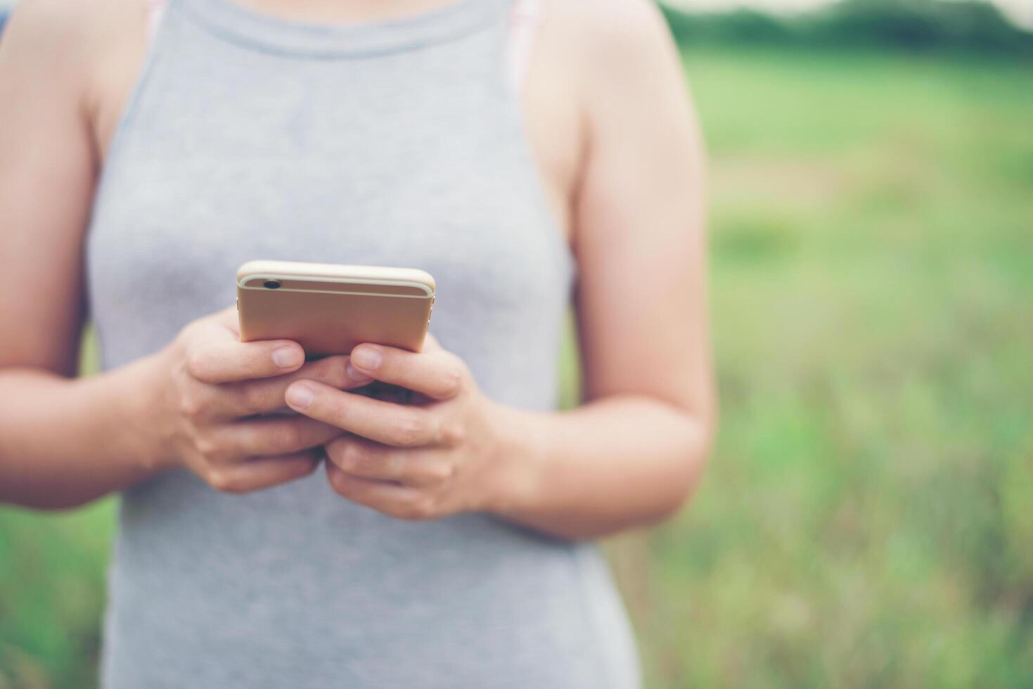 junge Frau Hände tippen Smartphone im Park. foto