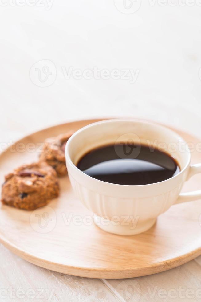 schwarzer Kaffee mit Keksen auf Holz foto