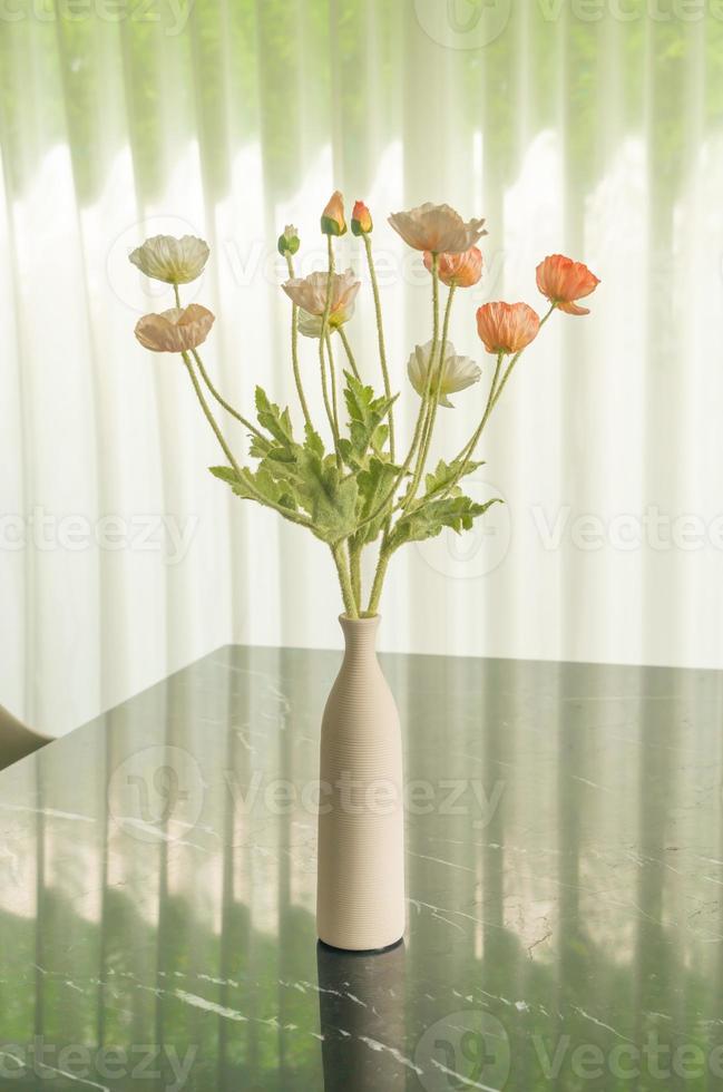 Mohnblume in Vasendekoration auf Esstisch foto