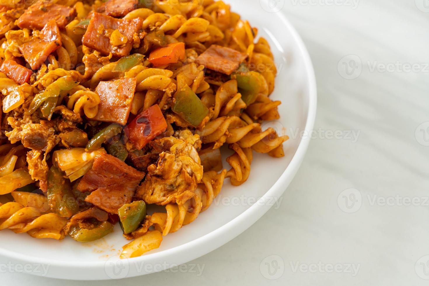 gebratene Fusilli-Nudeln mit Schinken und Tomatensauce foto