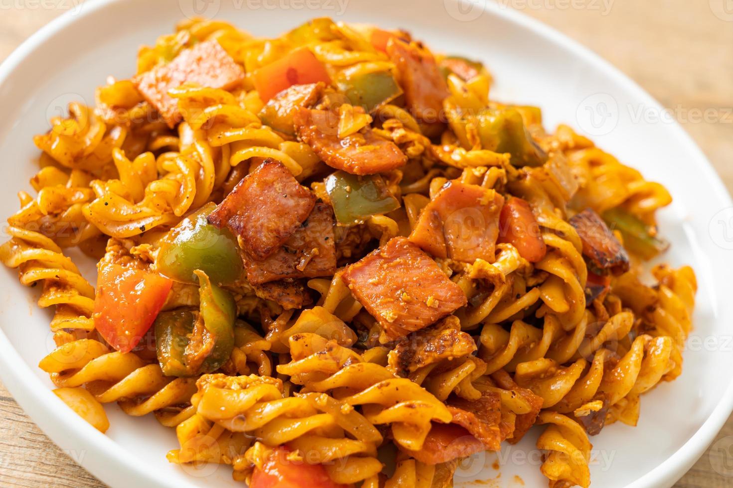 gebratene Fusilli-Nudeln mit Schinken und Tomatensauce foto