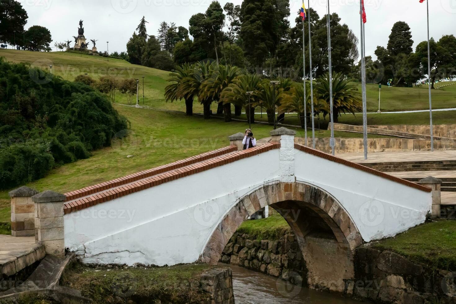 weiblich Tourist nehmen Bilder beim das berühmt historisch Brücke von Boyaca im Kolumbien. das kolumbianisch Unabhängigkeit Schlacht von Boyaca dauerte Platz Hier auf August 7, 1819. foto