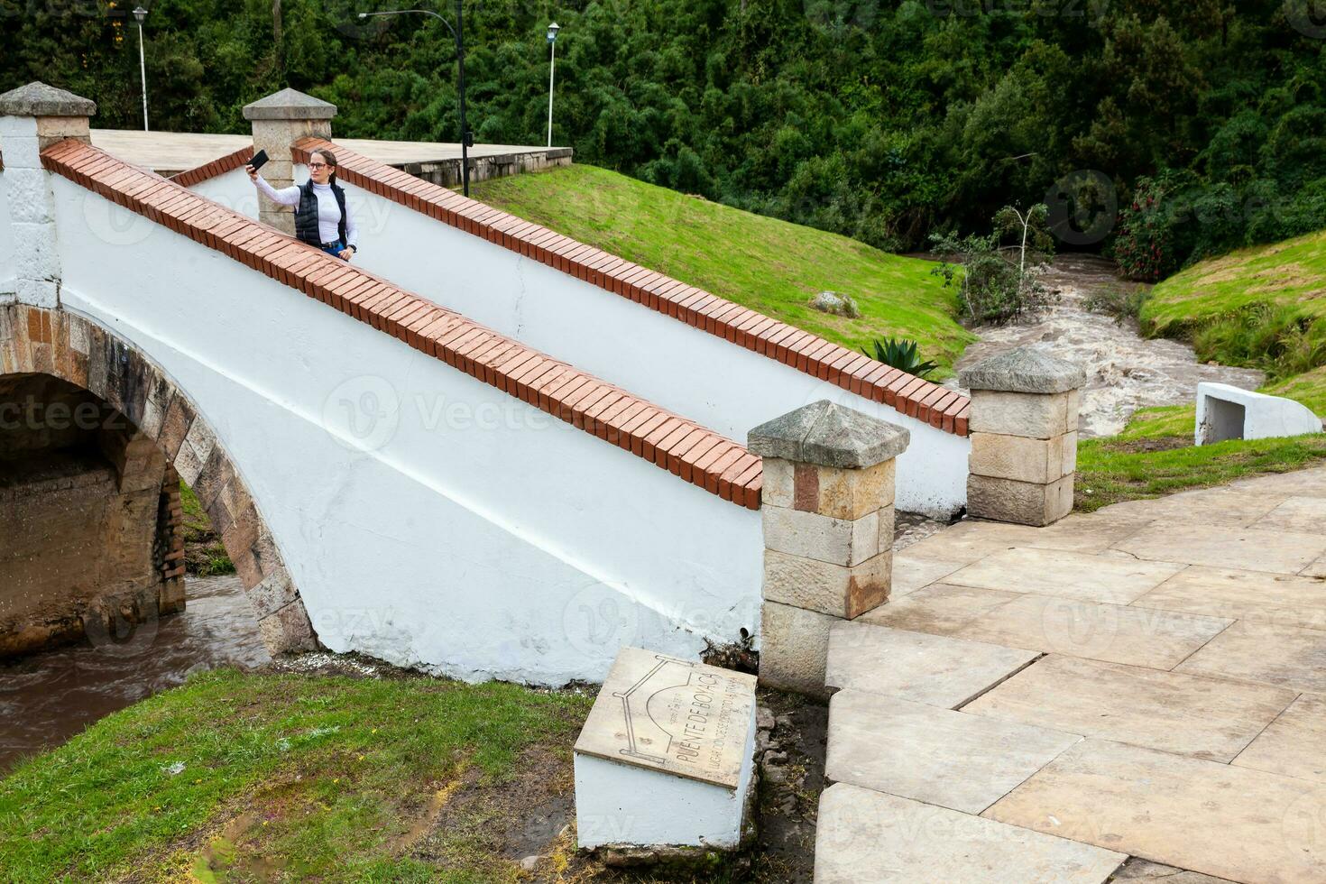 weiblich Tourist nehmen Selfies beim das berühmt historisch Brücke von Boyaca im Kolumbien. das kolumbianisch Unabhängigkeit Schlacht von Boyaca dauerte Platz Hier auf August 7, 1819. foto