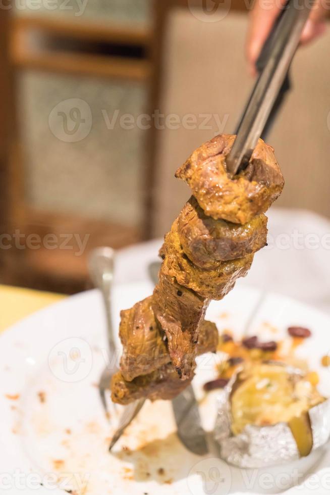 Schneiden von Steak nach brasilianischer Art auf Teller foto