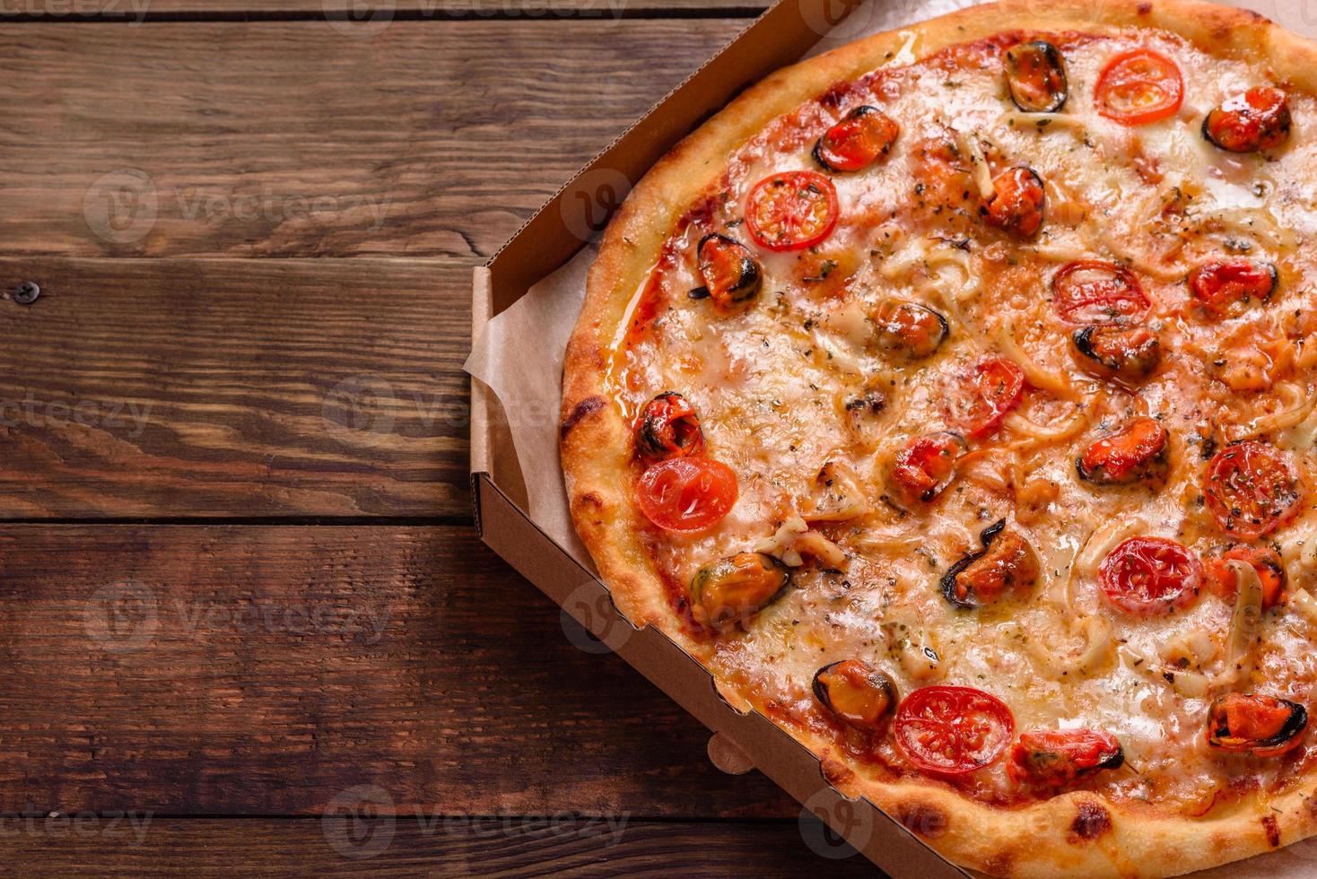 leckere Pizzascheiben mit Meeresfrüchten und Tomaten auf Betonuntergrund foto