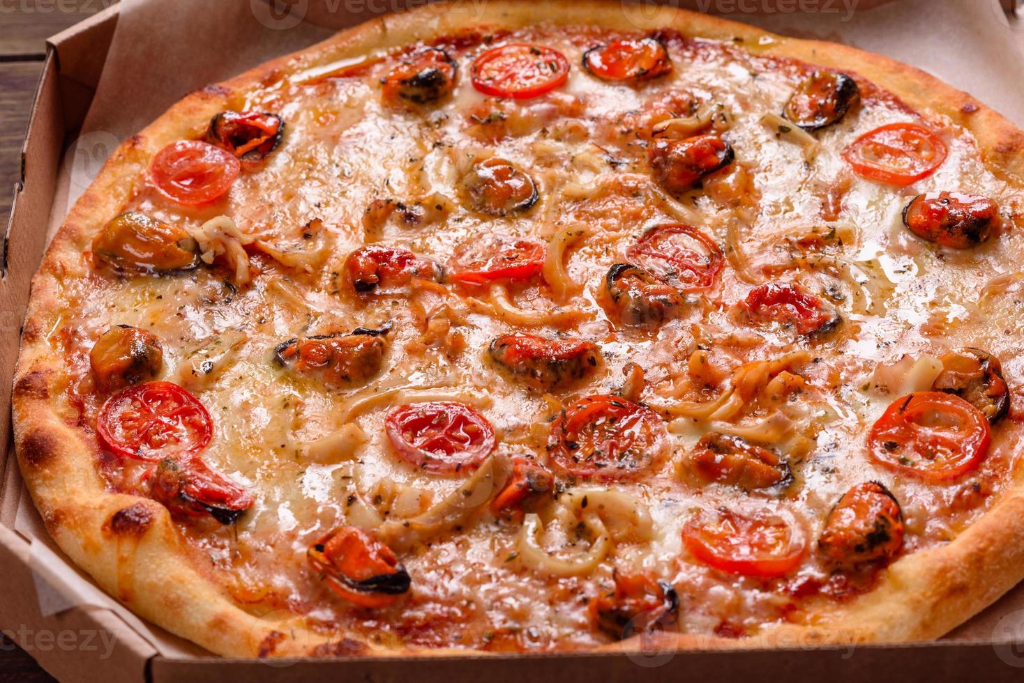 leckere Pizzascheiben mit Meeresfrüchten und Tomaten auf Betonuntergrund foto