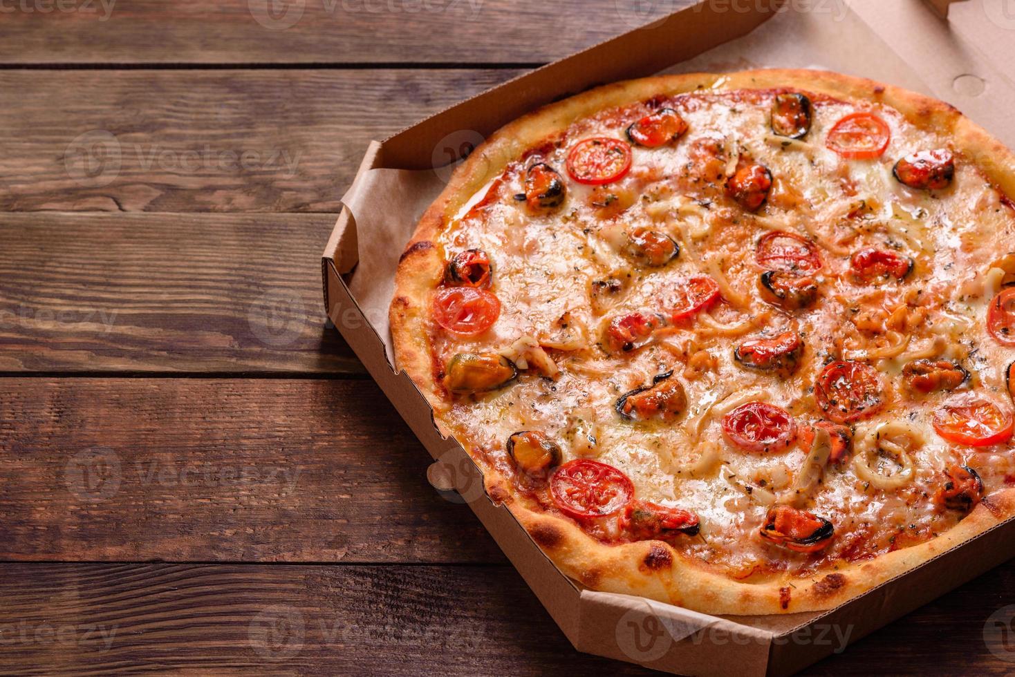 leckere Pizzascheiben mit Meeresfrüchten und Tomaten auf Betonuntergrund foto