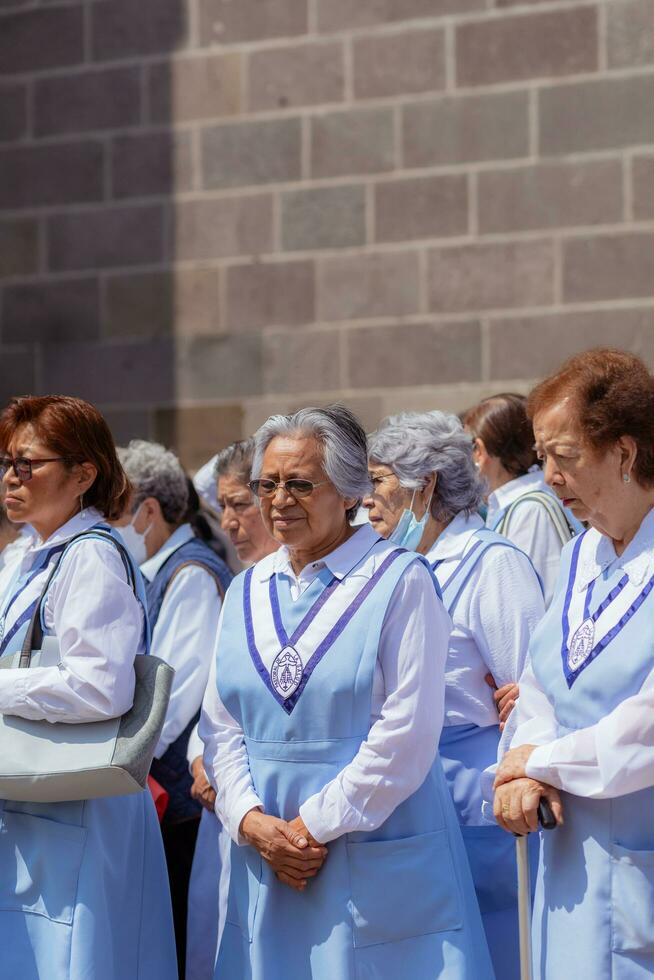 Puebla, Mexiko 2023 - - Priester und Mitglieder von das katholisch Kirche tragen aus ein Prozession im Vorderseite von das Kathedrale von Puebla. Anbetung von katholisch Christian Symbole foto