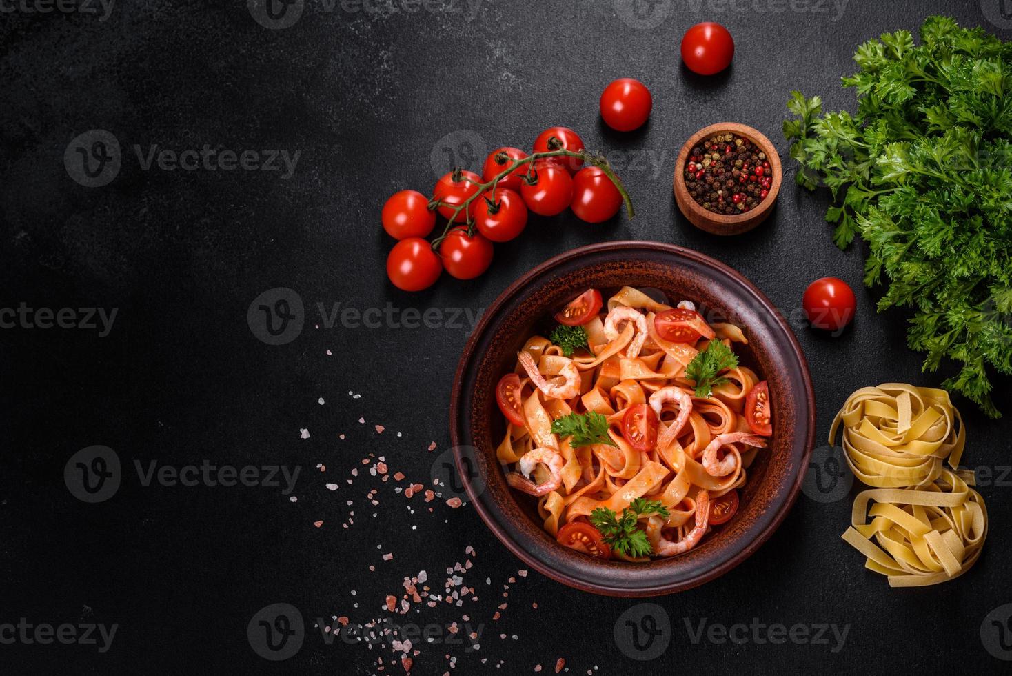 Fettuccine-Nudeln mit Garnelen, Kirschtomaten, Sauce, Gewürzen und Kräutern foto