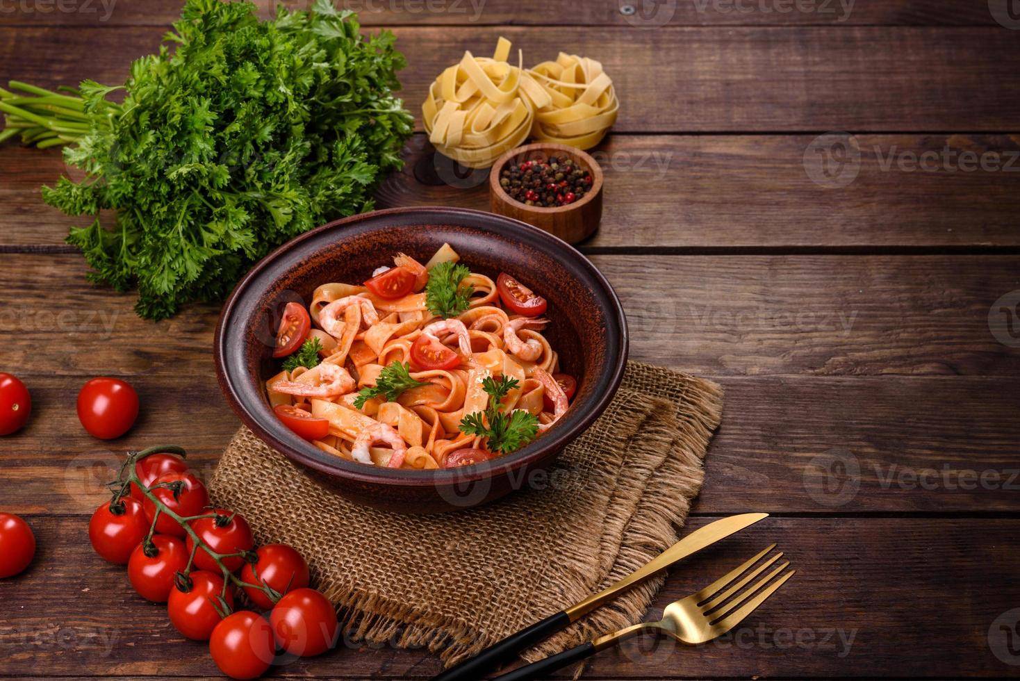 Fettuccine-Nudeln mit Garnelen, Kirschtomaten, Sauce, Gewürzen und Kräutern foto