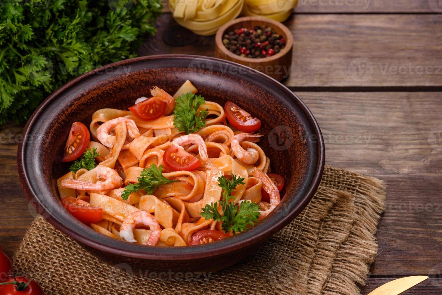 Fettuccine-Nudeln mit Garnelen, Kirschtomaten, Sauce, Gewürzen und Kräutern foto