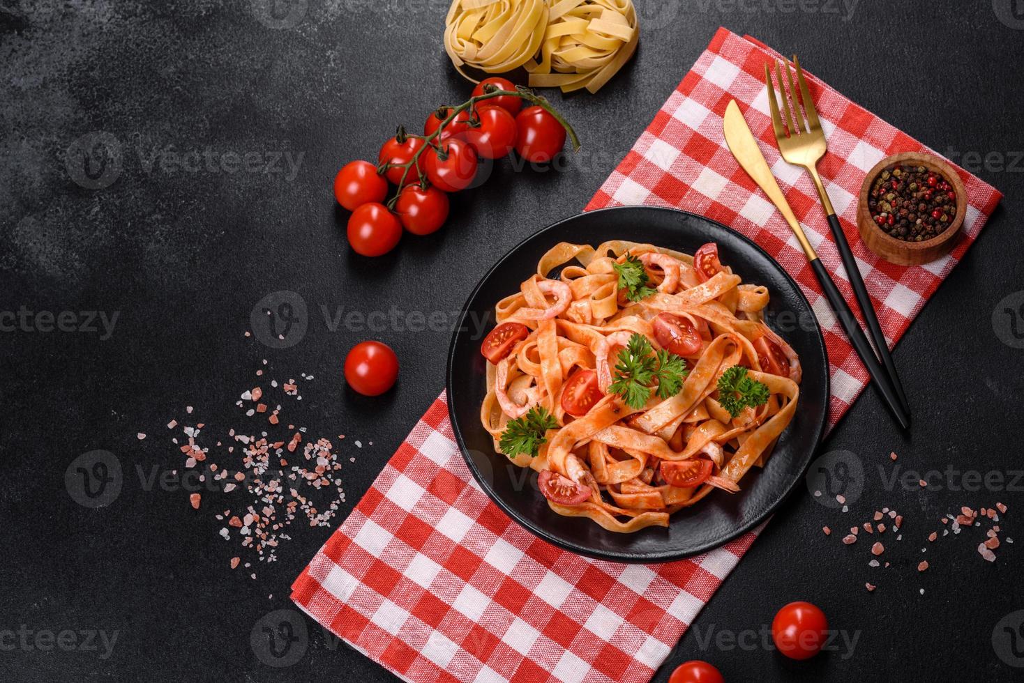 Fettuccine-Nudeln mit Garnelen, Kirschtomaten, Sauce, Gewürzen und Kräutern foto