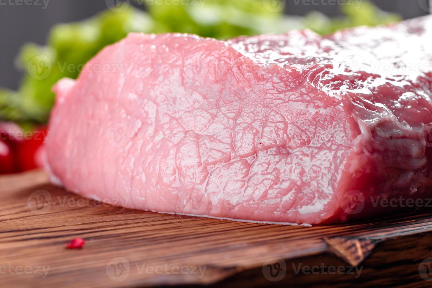 frische Stücke Schweinefleisch kochfertig auf dunklem Hintergrund foto