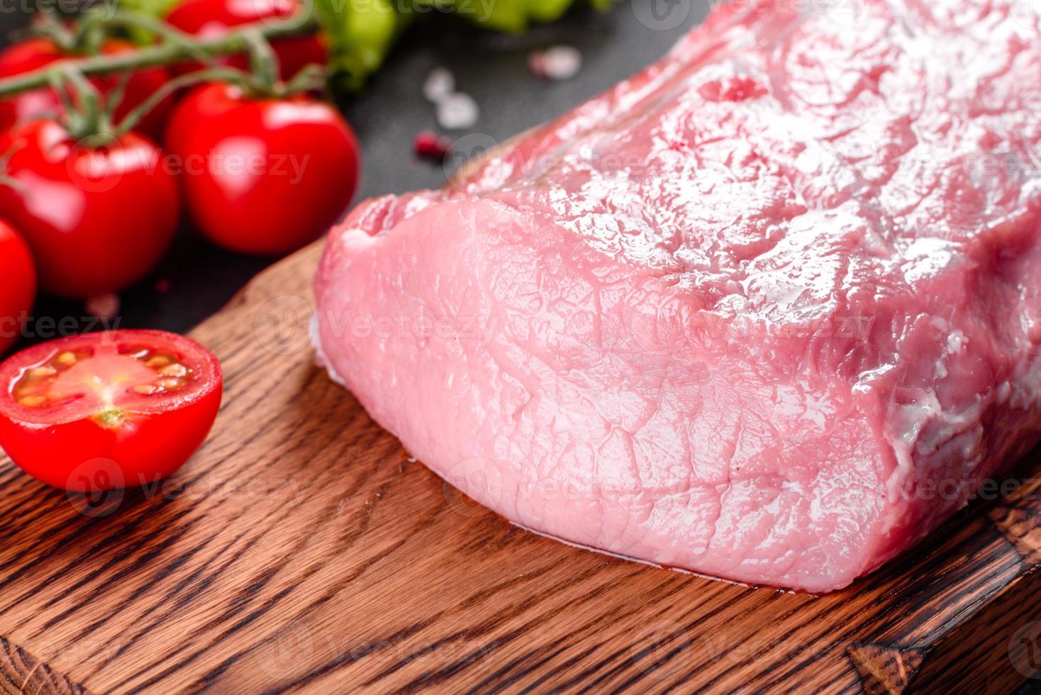 frische Stücke Schweinefleisch kochfertig auf dunklem Hintergrund foto