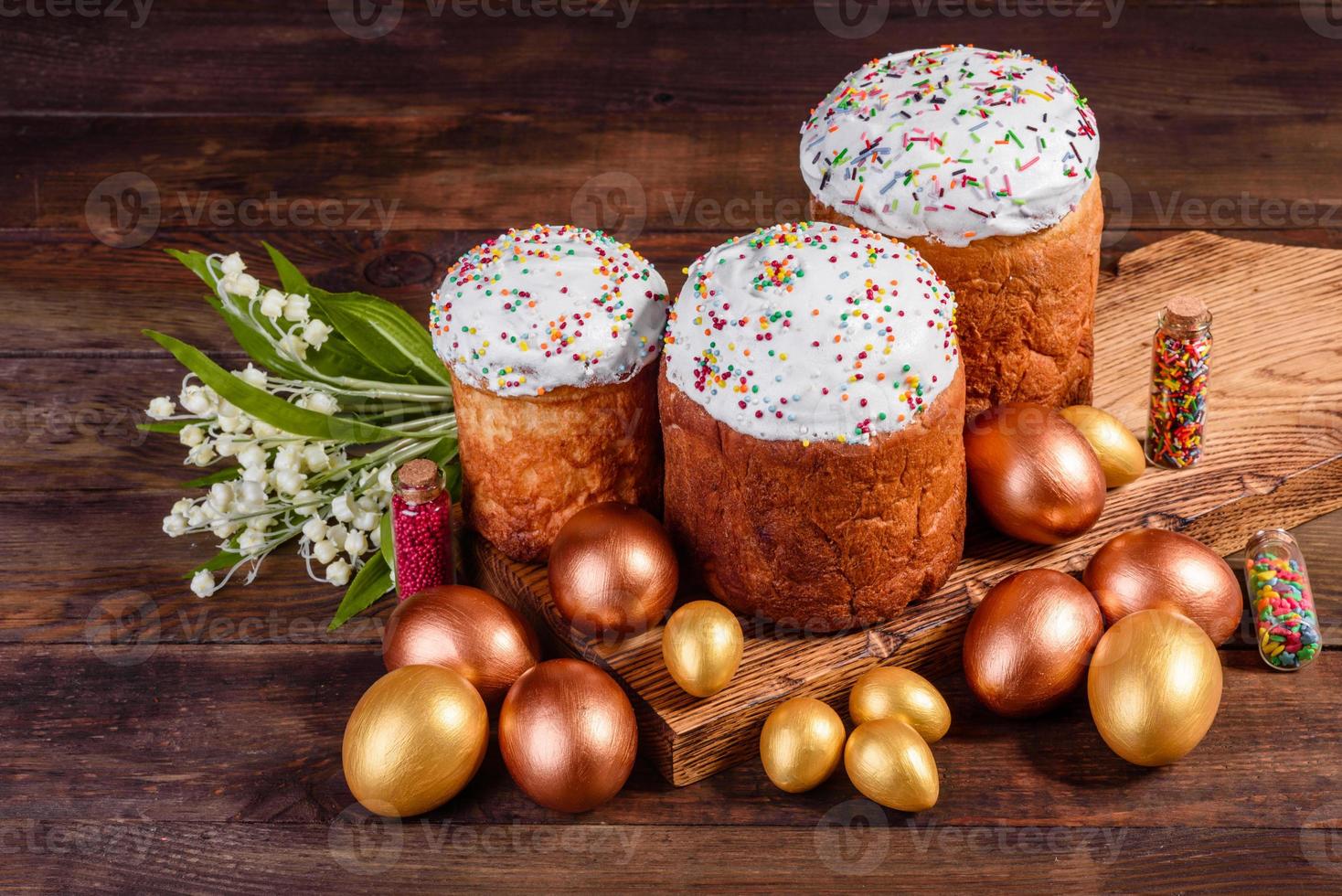 Ostereier Gold und Bronze und Osterkuchen auf dunklem Hintergrund foto