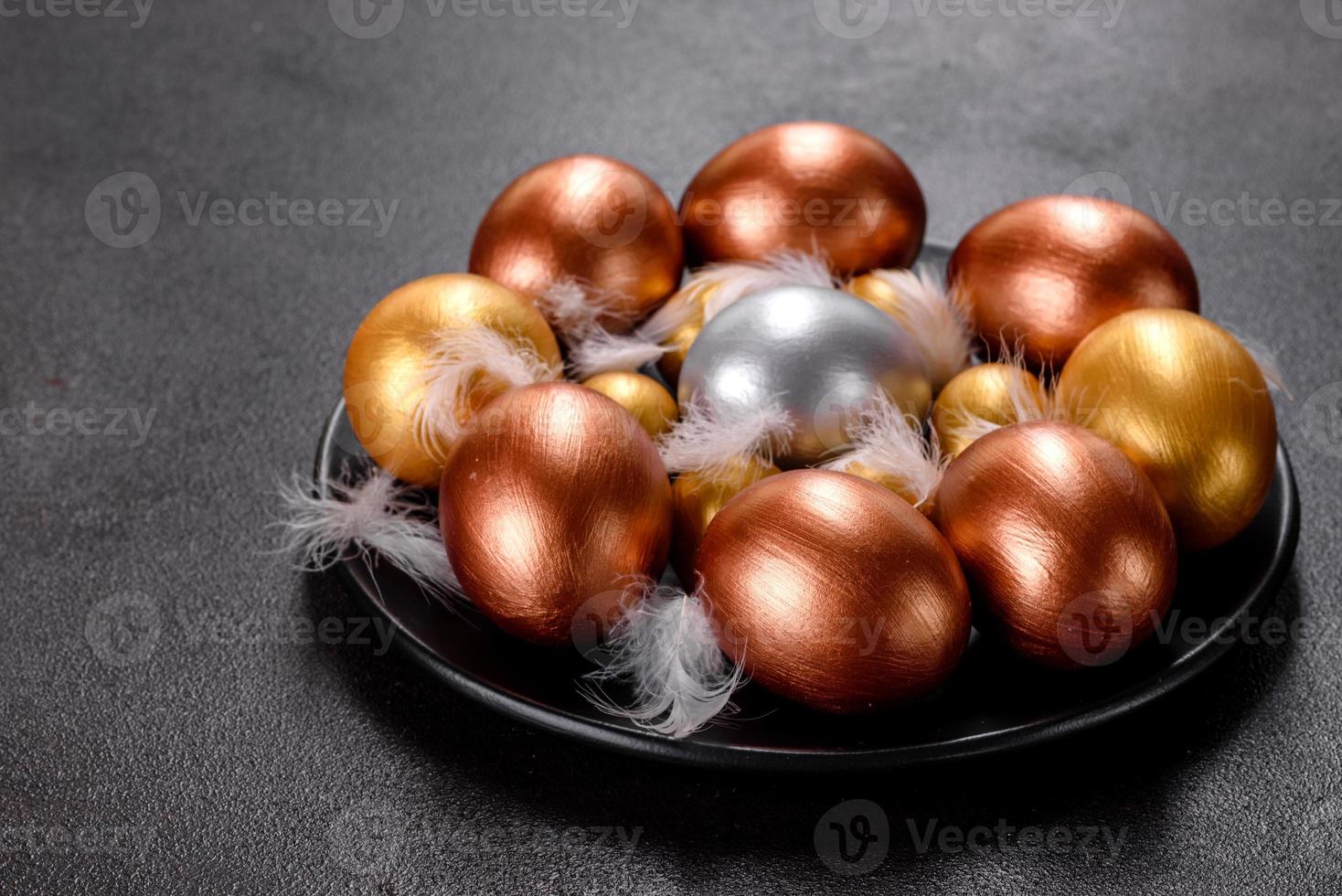 Ostereier Gold und Bronze und Osterkuchen auf dunklem Hintergrund foto