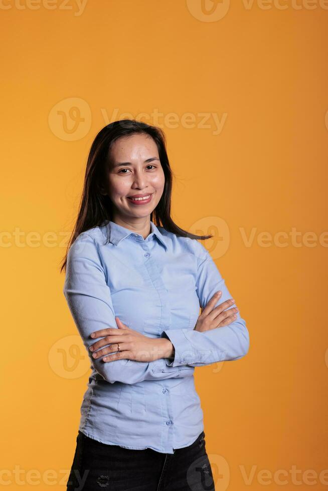 heiter Filipino Modell- mit Brünette lange Haar und Herrlich lächelnd, tragen formal während Studio Schuss. sorglos zuversichtlich Modell- haben komisch Ausdruck Stehen Über Gelb Hintergrund foto