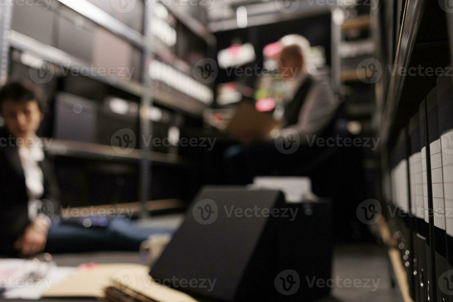 selektiv Fokus von Lager voll mit Ermittlung Beweise Dateien, im Hintergrund Kriminologie Mannschaft Analysieren Verbrechen Szene Bericht. Privat Detektive Arbeiten im Laufe der Zeit beim Bundes Fall im ankommen Zimmer foto