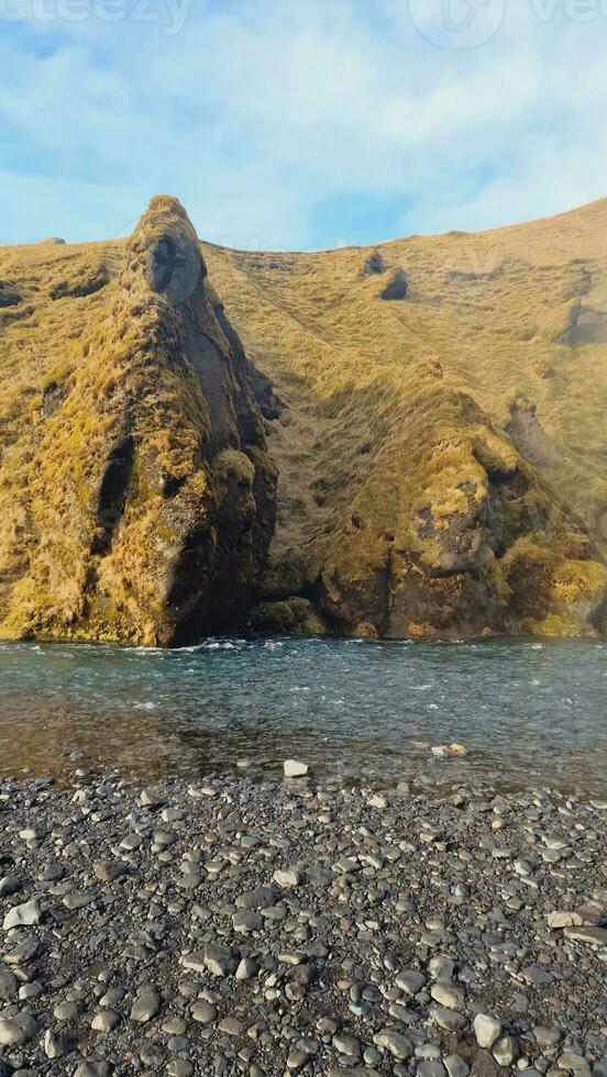 felsig Hänge und Wasser Strom im Island, schneebedeckt Berge im nordisch Senke Bildung majestätisch Arktis Landschaft. Fantastisch Landschaft Weiden und Klippen, malerisch Hochland. foto