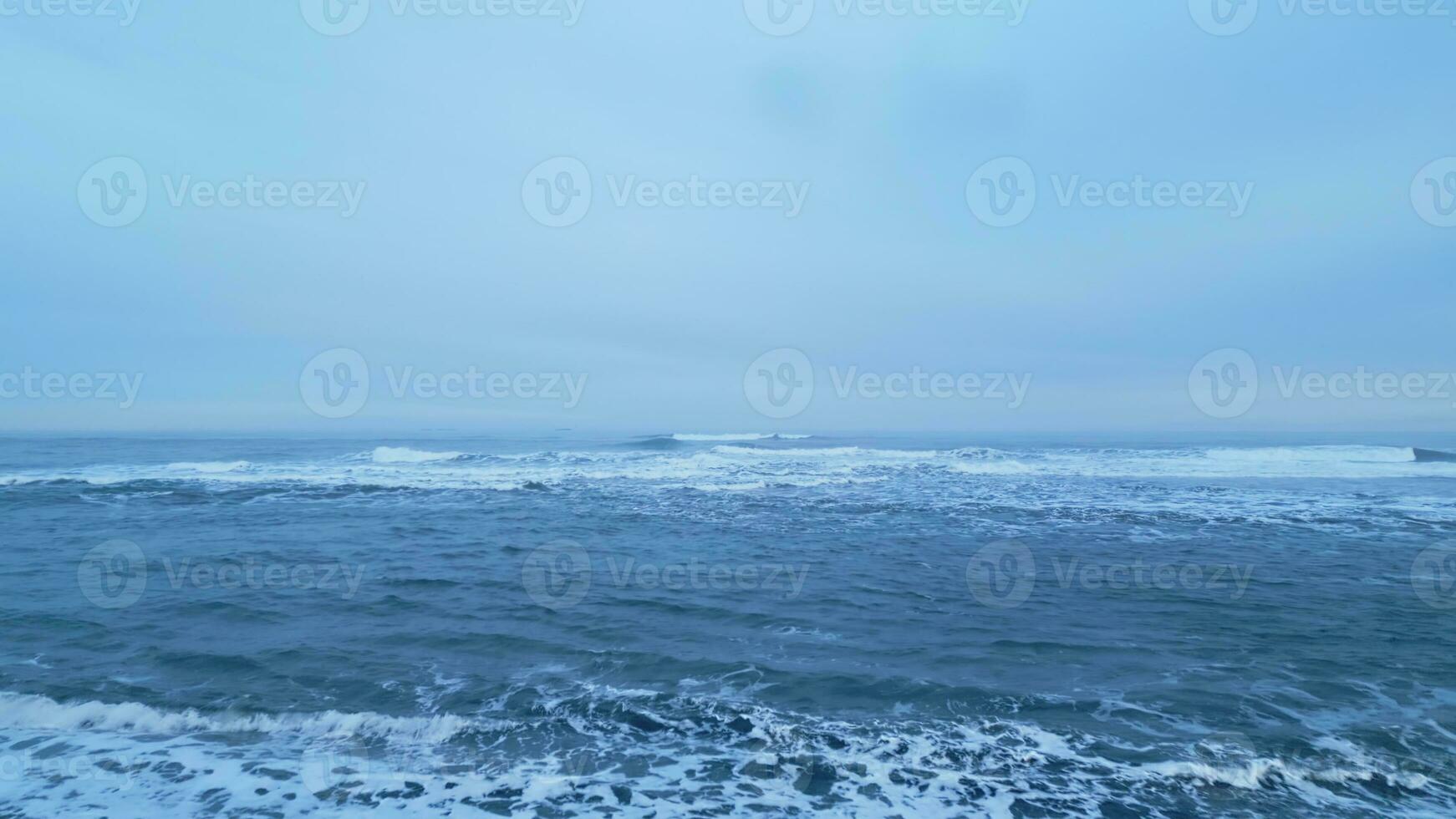 isländisch Landschaft schwarz Sand Strand mit Ozean Küste, schön Arktis Land mit natürlich Landschaft. Antenne Aussicht von Island Natur mit Wellen abstürzen auf atlantisch Ufer. schleppend Bewegung. foto