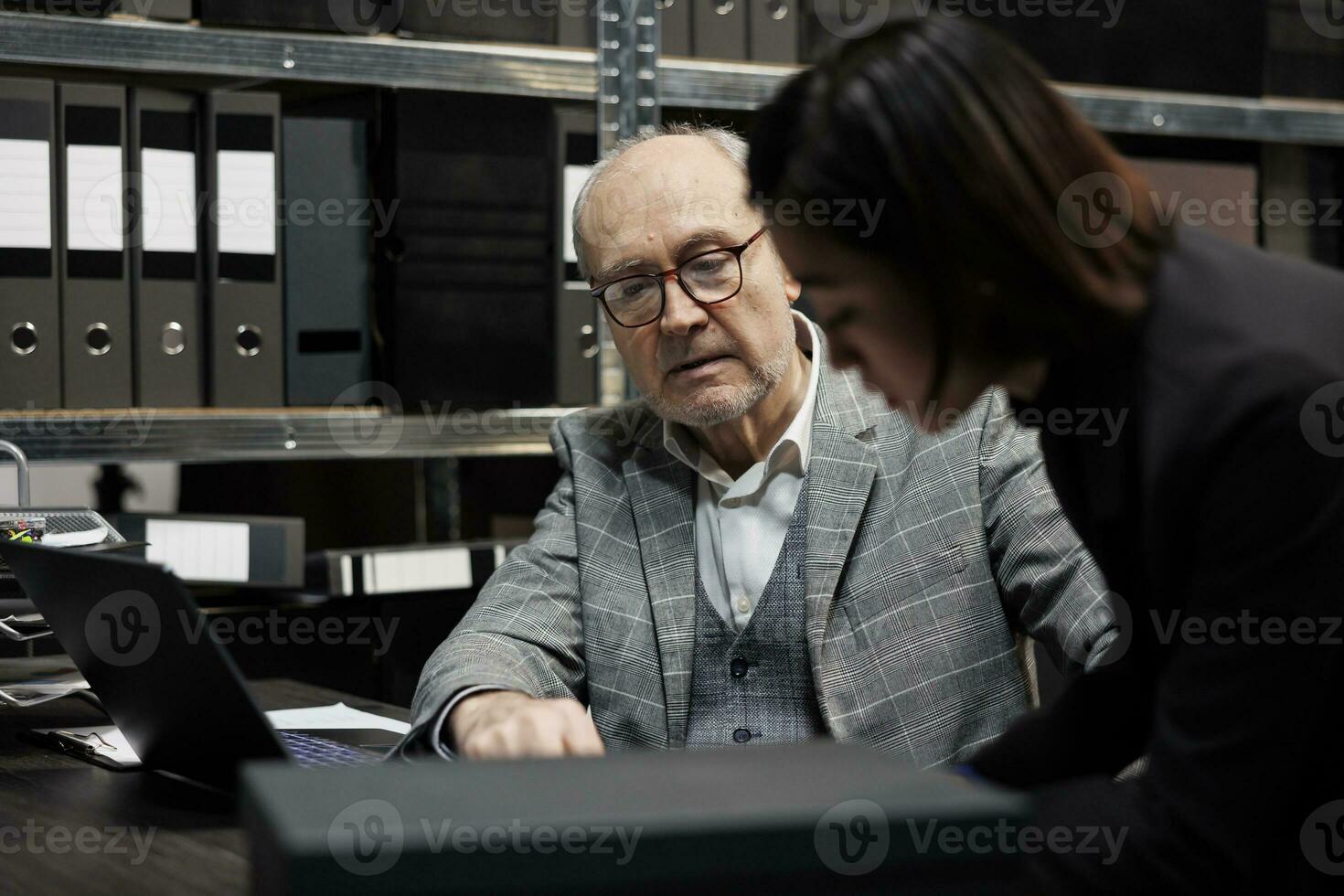 Fachmann Rechnungswesen Führungskräfte unterstellen Buchhaltung administrative Daten Papierkram auf Laptop. Bürokratie Archivierung Kabinett Zimmer gefüllt mit Ordner und Diagramm Diagramme foto