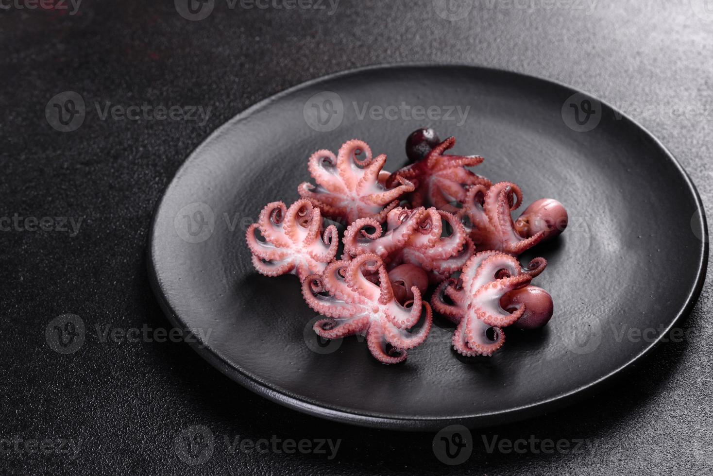 Meeresfrüchte-Baby-Oktopus-Salat in einem schwarzen Teller foto