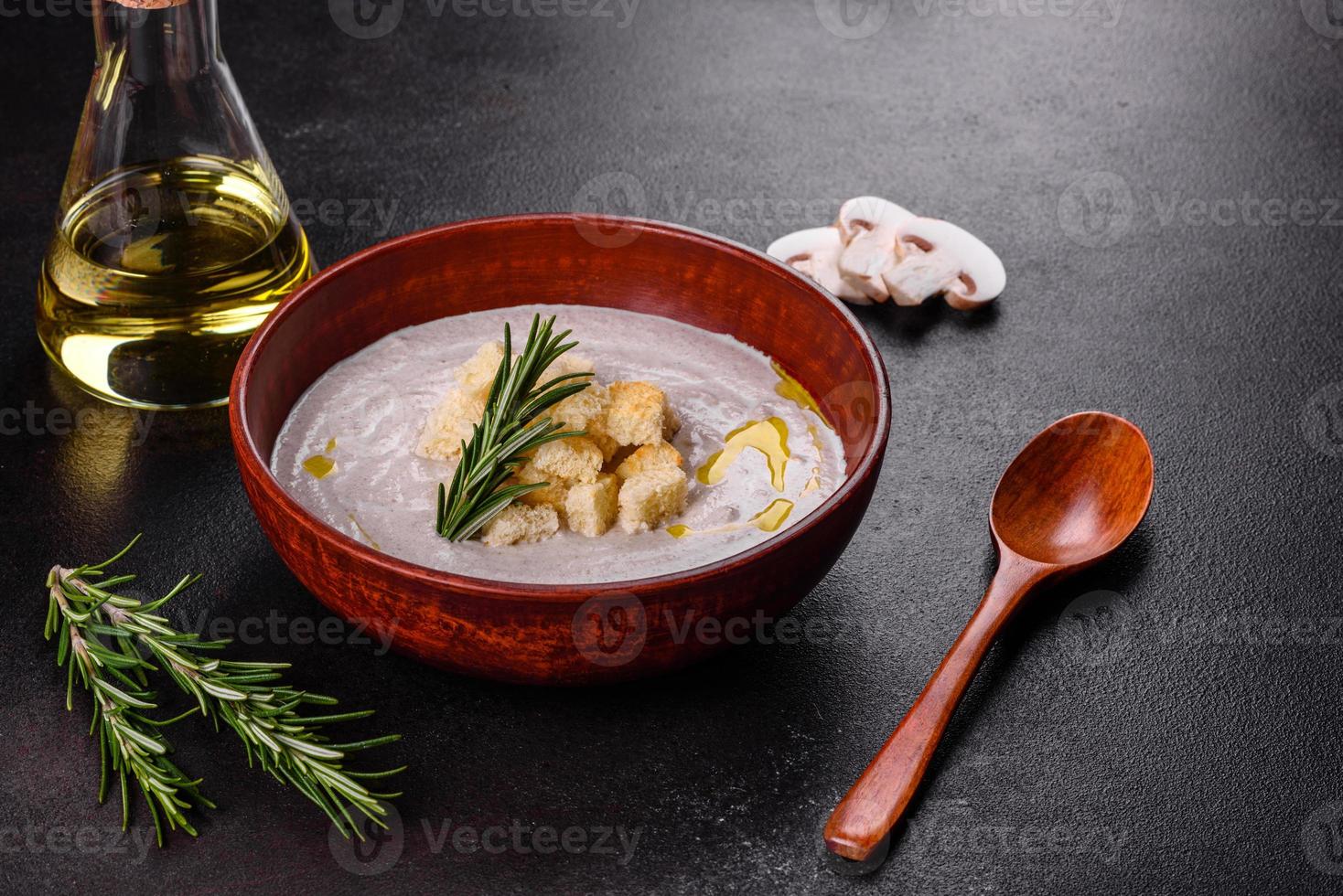 köstliche schöne Pilzsuppe in einem braunen Teller mit einem Holzlöffel foto