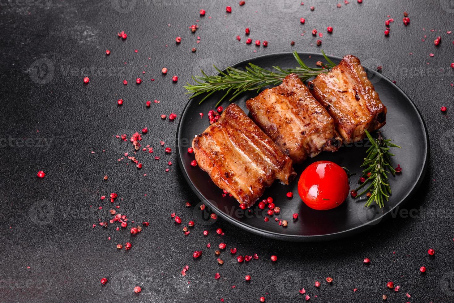 gebratene Rippchen mit Rosmarin, Zwiebeln, Sauce auf Betonuntergrund foto