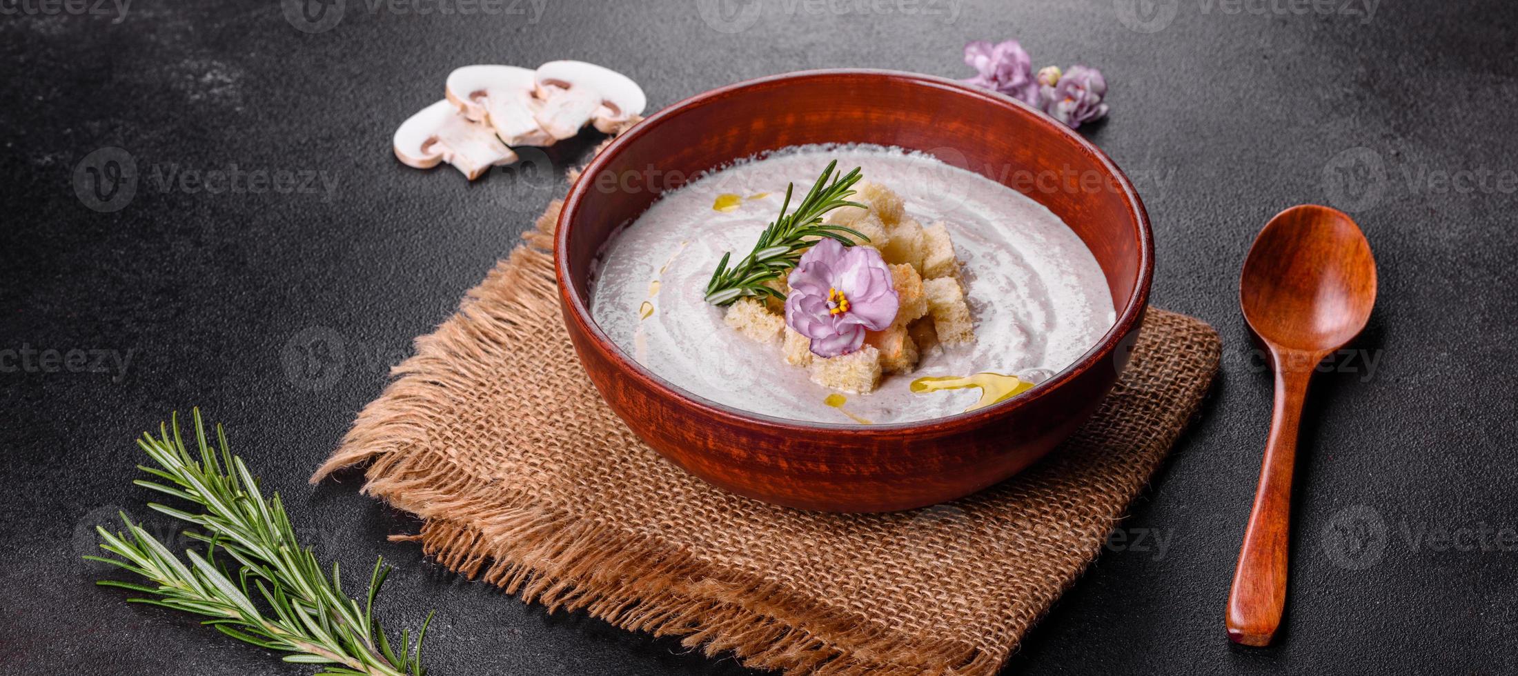 köstliche schöne Pilzsuppe in einem braunen Teller mit einem Holzlöffel foto