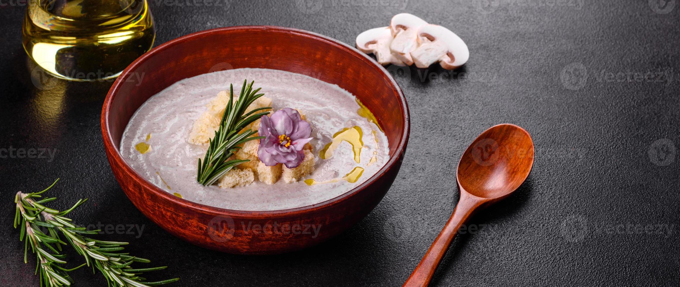 köstliche schöne Pilzsuppe in einem braunen Teller mit einem Holzlöffel foto