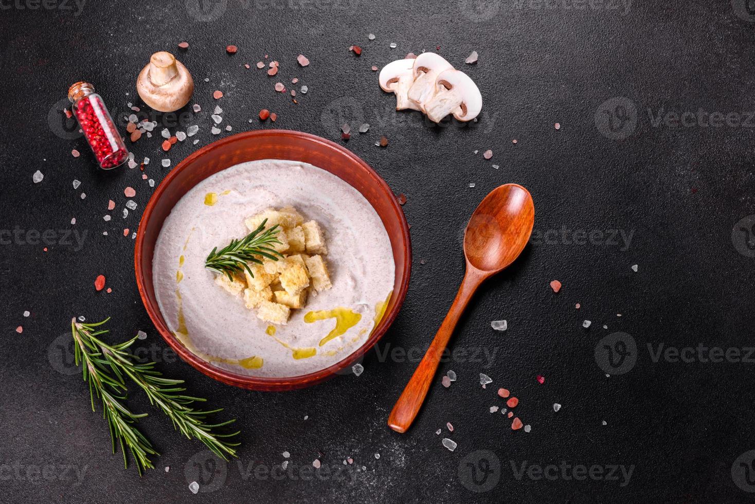 köstliche schöne Pilzsuppe in einem braunen Teller mit einem Holzlöffel foto