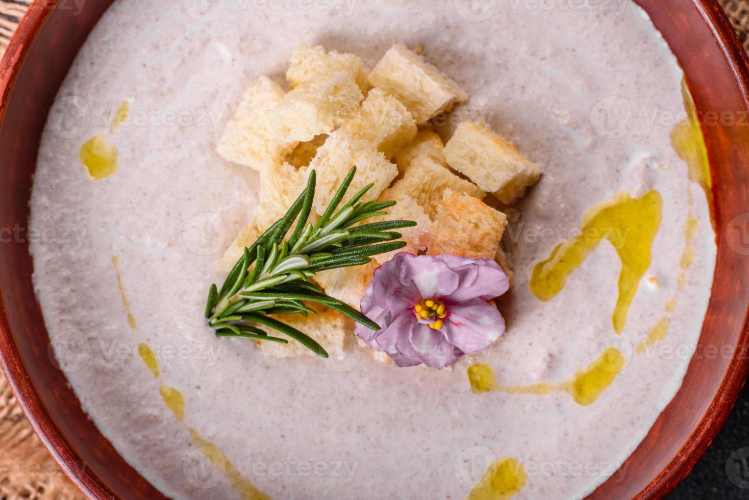 köstliche schöne Pilzsuppe in einem braunen Teller mit einem Holzlöffel foto