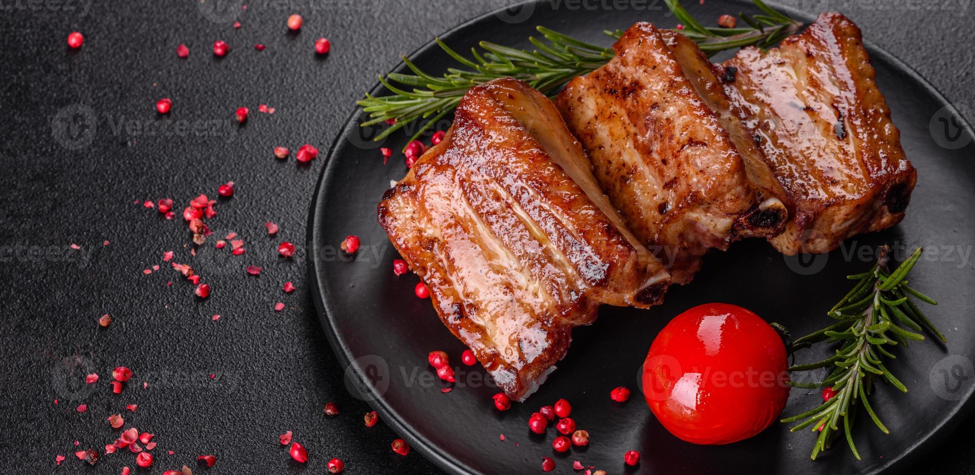 gebratene Rippchen mit Rosmarin, Zwiebeln, Sauce auf Betonuntergrund foto