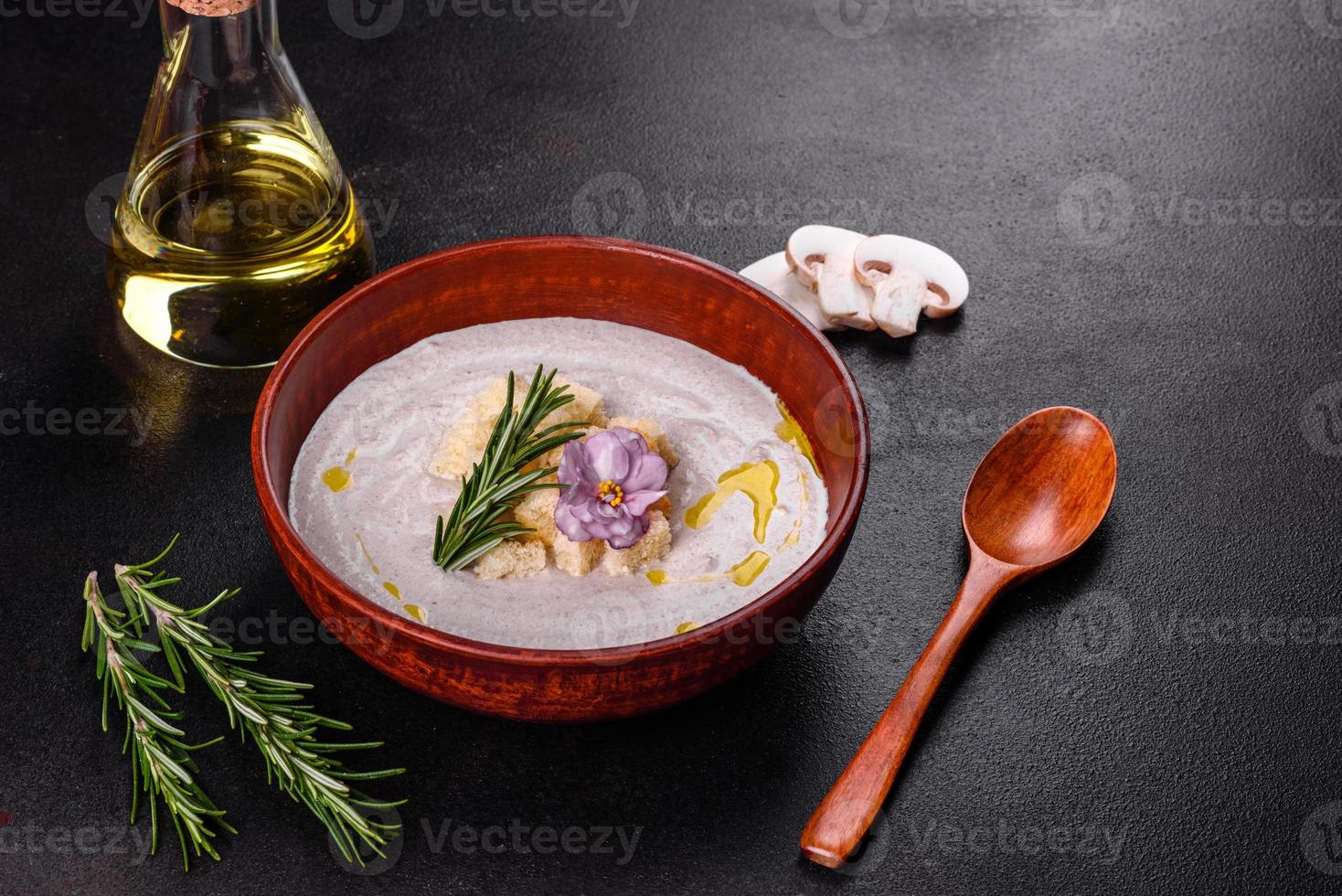 köstliche schöne Pilzsuppe in einem braunen Teller mit einem Holzlöffel foto