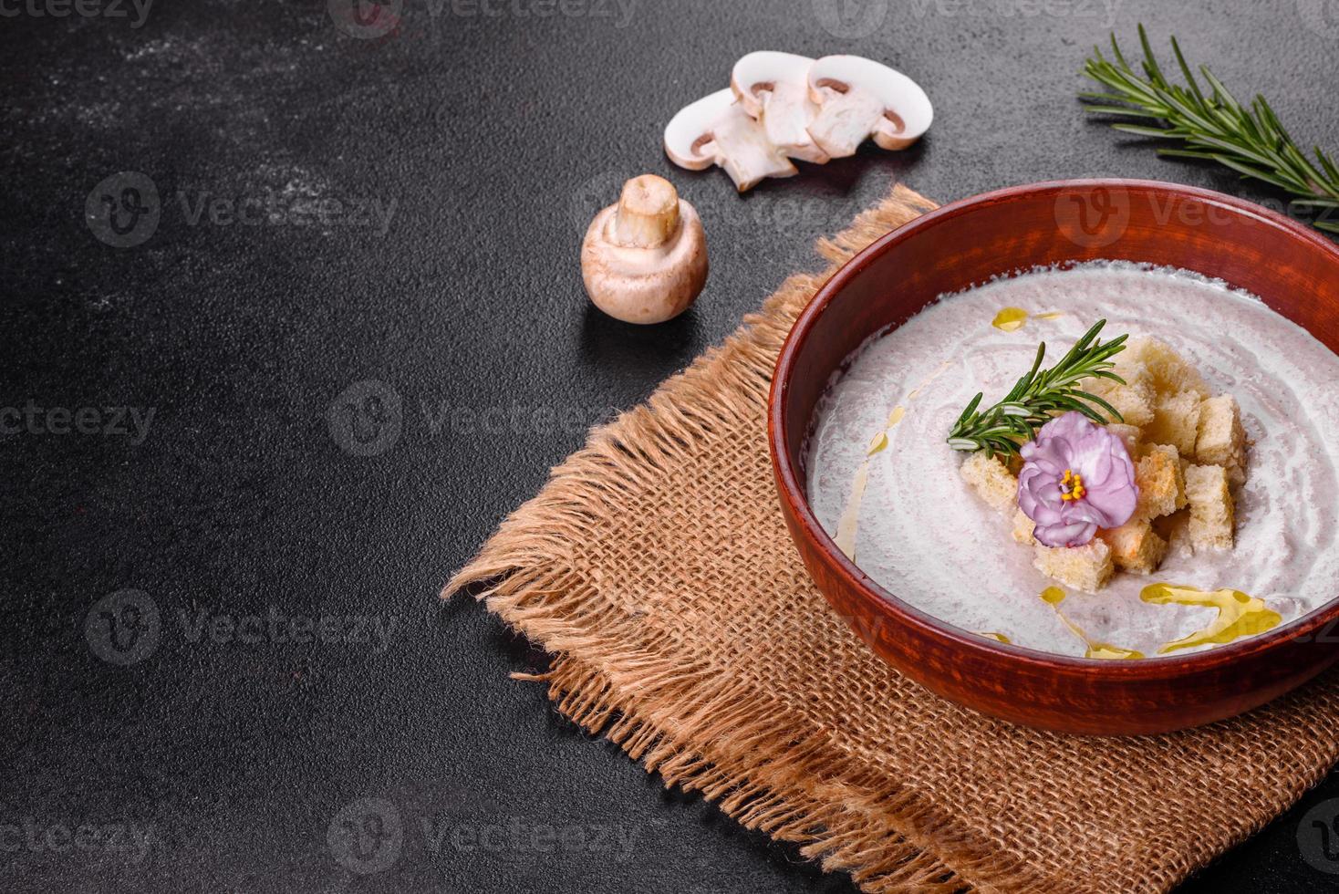 köstliche schöne Pilzsuppe in einem braunen Teller mit einem Holzlöffel foto