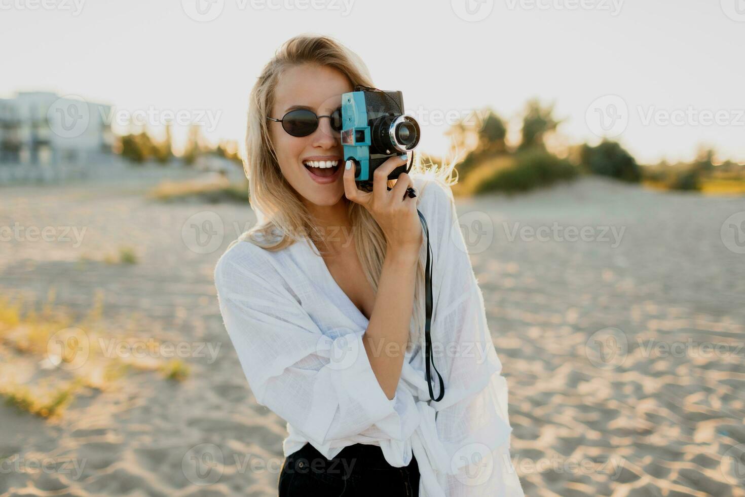 stilvoll Mädchen mit retro Kamera auf sonnig Strand. Sommer- Urlaub. Freiheit und Reise Konzept. foto