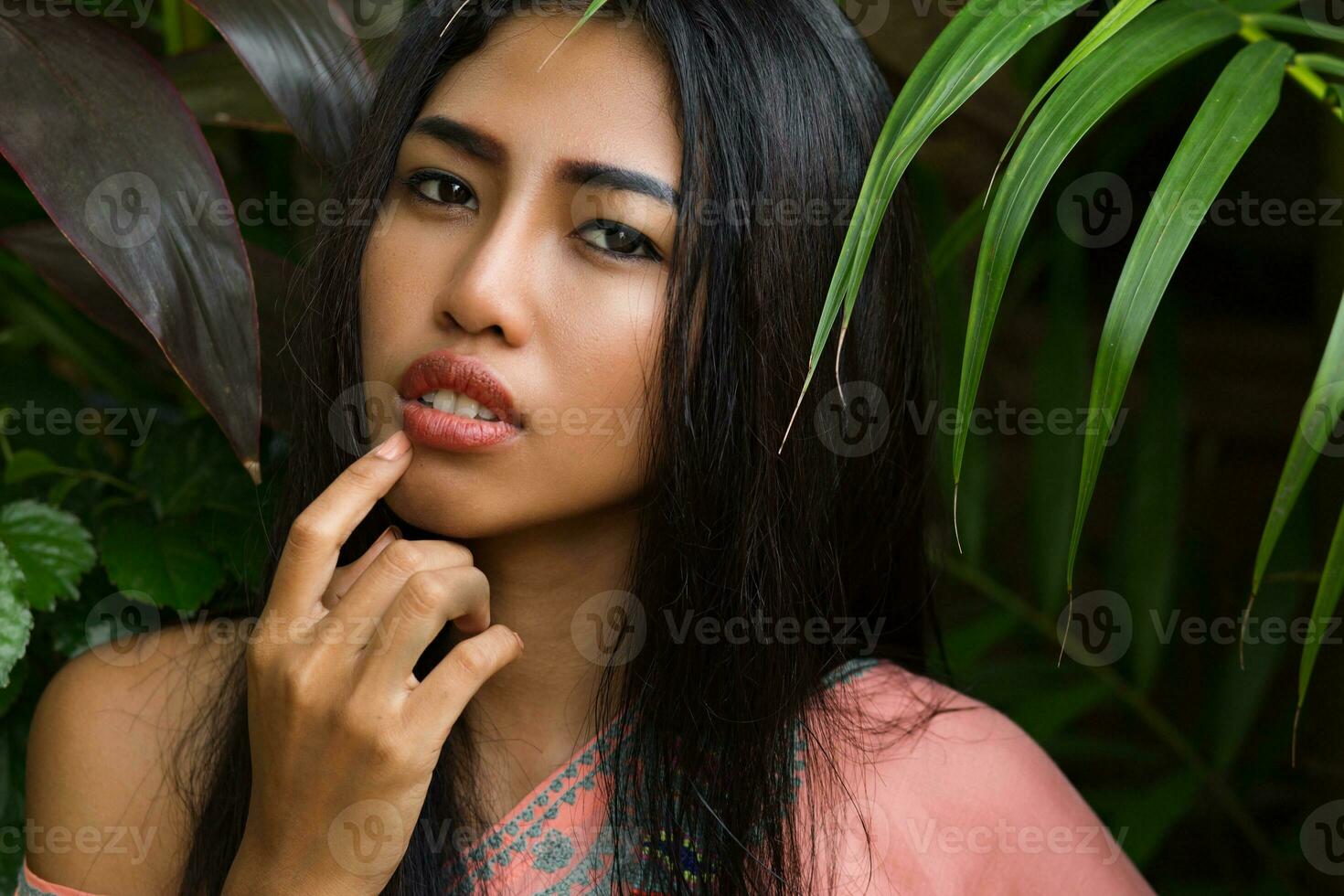 schließen oben Porträt von schön thailändisch Frau Über tropisch Blätter Hintergrund. foto