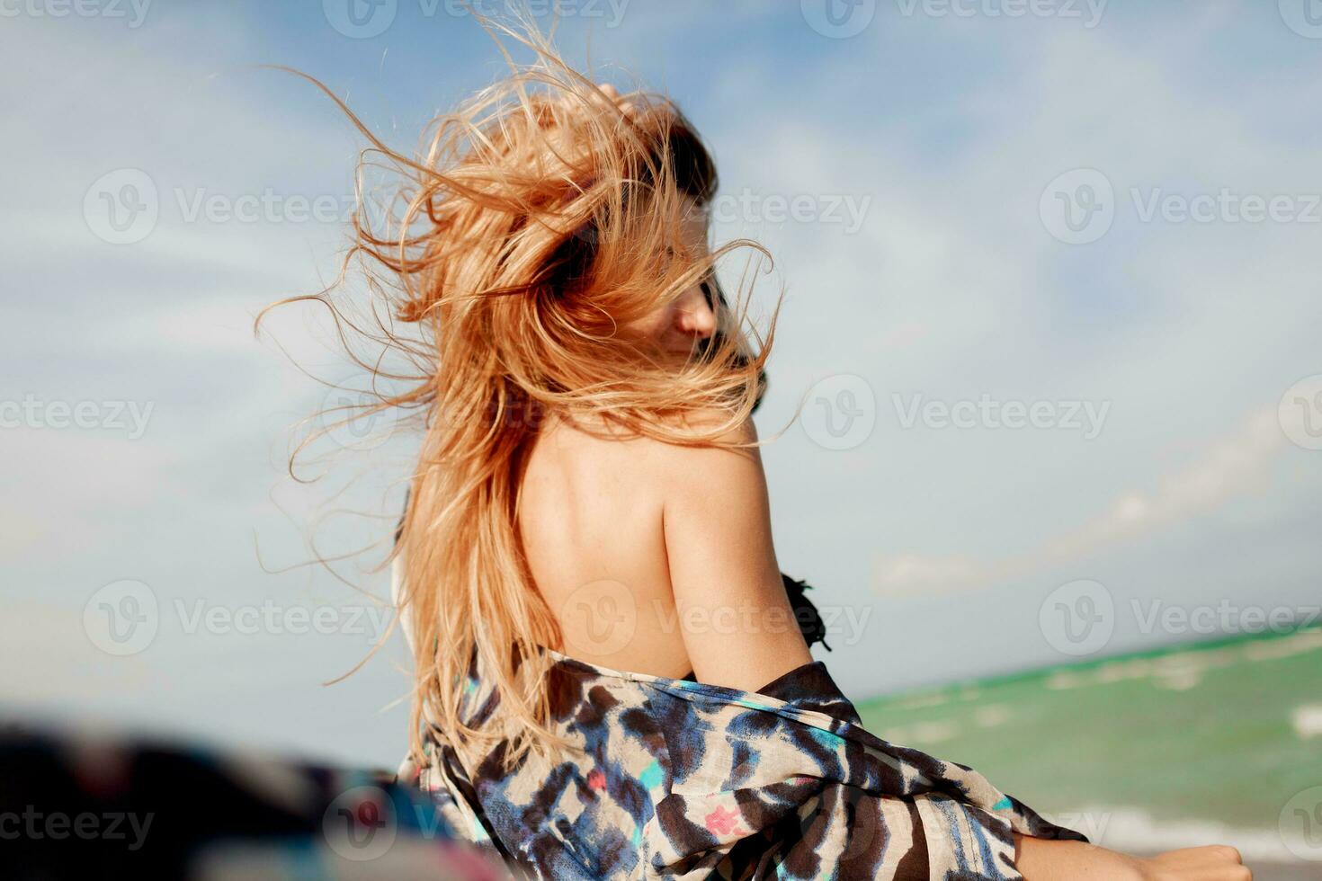 sorglos Frau Springen Freiheit auf Weiß Sand. Blau Ozean Hintergrund. windig Haare. foto