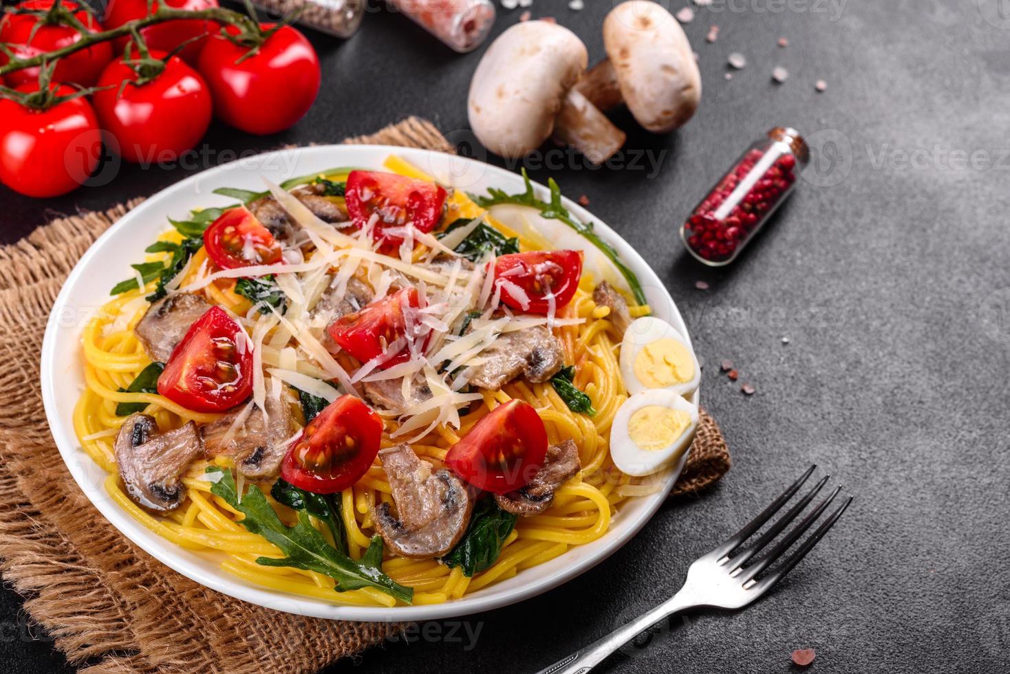 Spaghetti mit Champignons, Käse, Spinat, Rukkola und Cherrytomaten foto