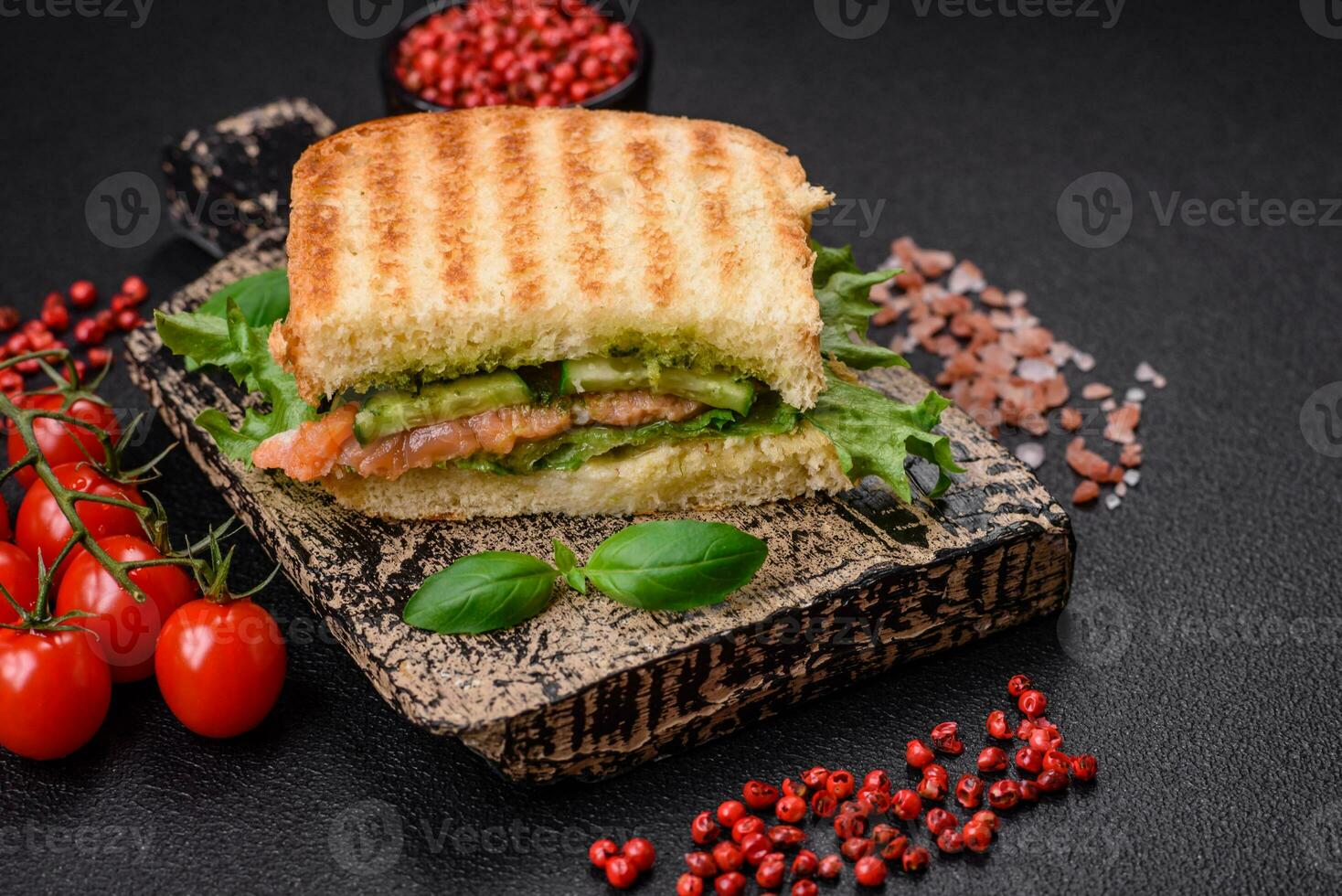 köstlich knusprig Sandwich mit Toast, Lachs, Avocado, Tomaten, Salz, Gewürze und Kräuter foto