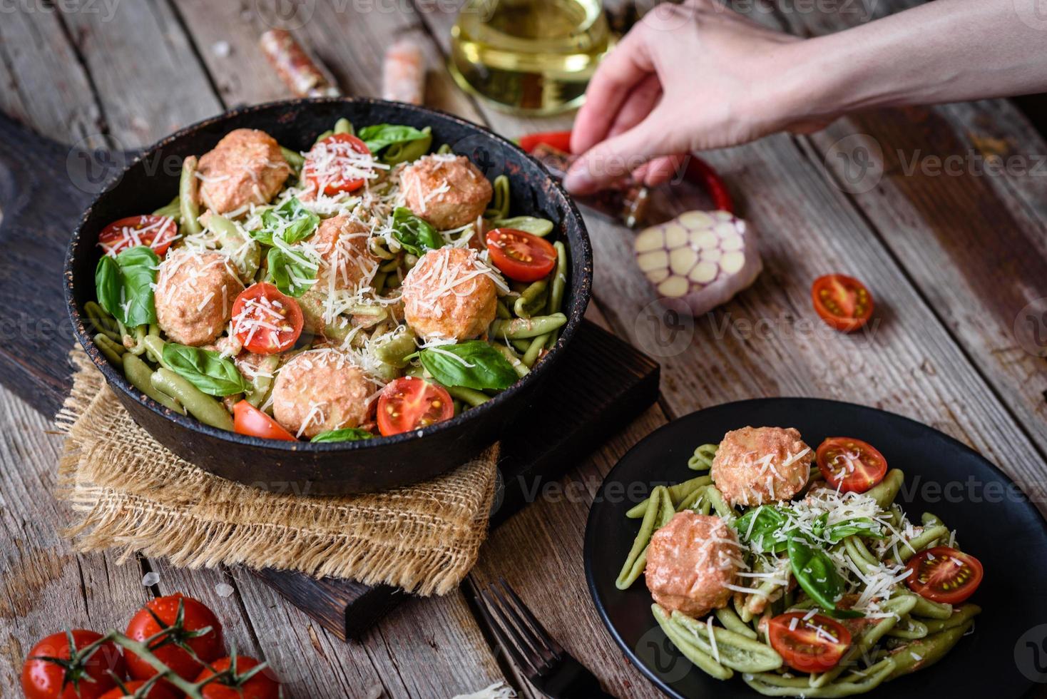 leckere frische Pasta mit Fleischbällchen, Sauce, Cherrytomaten und Basilikum foto