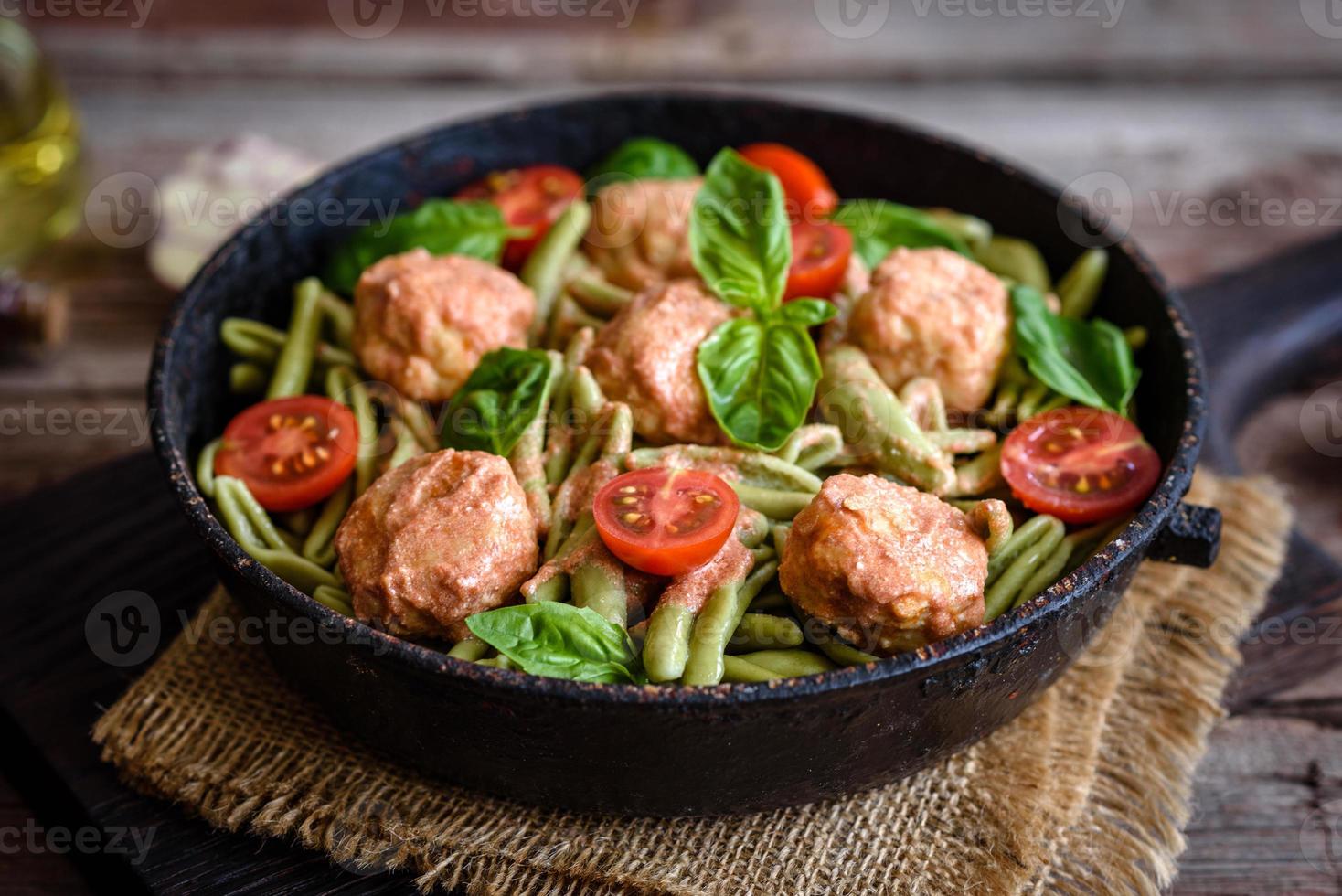 leckere frische Pasta mit Fleischbällchen, Sauce, Cherrytomaten und Basilikum foto